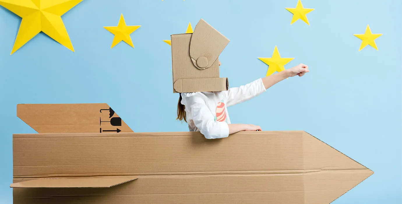 A kid in a cardboard rocket — scrappy innovation